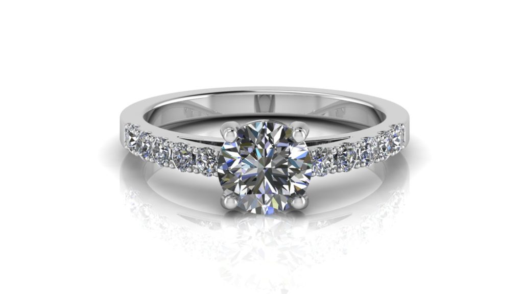 White gold engagement ring featuring a claw set round diamond with smaller diamonds down the band