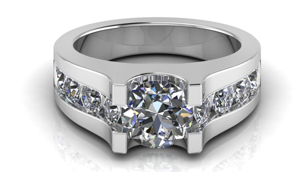 White gold engagement ring featuring a round diamond with smaller channel set diamonds down the band