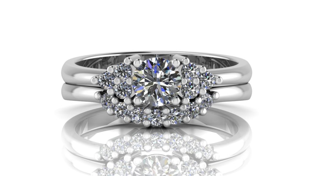 White gold engagement and matching wedding band featuring a round diamond with smaller diamonds set on the sides