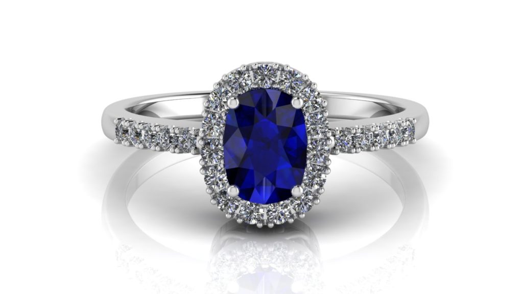 White gold halo engagement ring featuring an oval cut ceylon sapphire and smaller diamonds down the band
